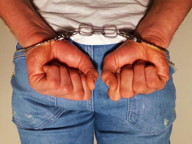 Handcuffs on arrested man hand, man loss freedom