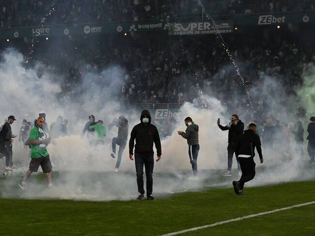 Saint-Etienne&#039;s fans invade the pitch through smoke after being defeated at the end of the French L1-L2 play-off second leg football match between AS Saint-Etienne and AJ Auxerre at the Geoffroy Guichard Stadium in Saint-Etienne, central-eastern France on May 29, 2022. (Photo by JEAN-PHILIPPE KSIAZEK / AFP) (Photo by JEAN-PHILIPPE KSIAZEK/AFP via Getty Images)