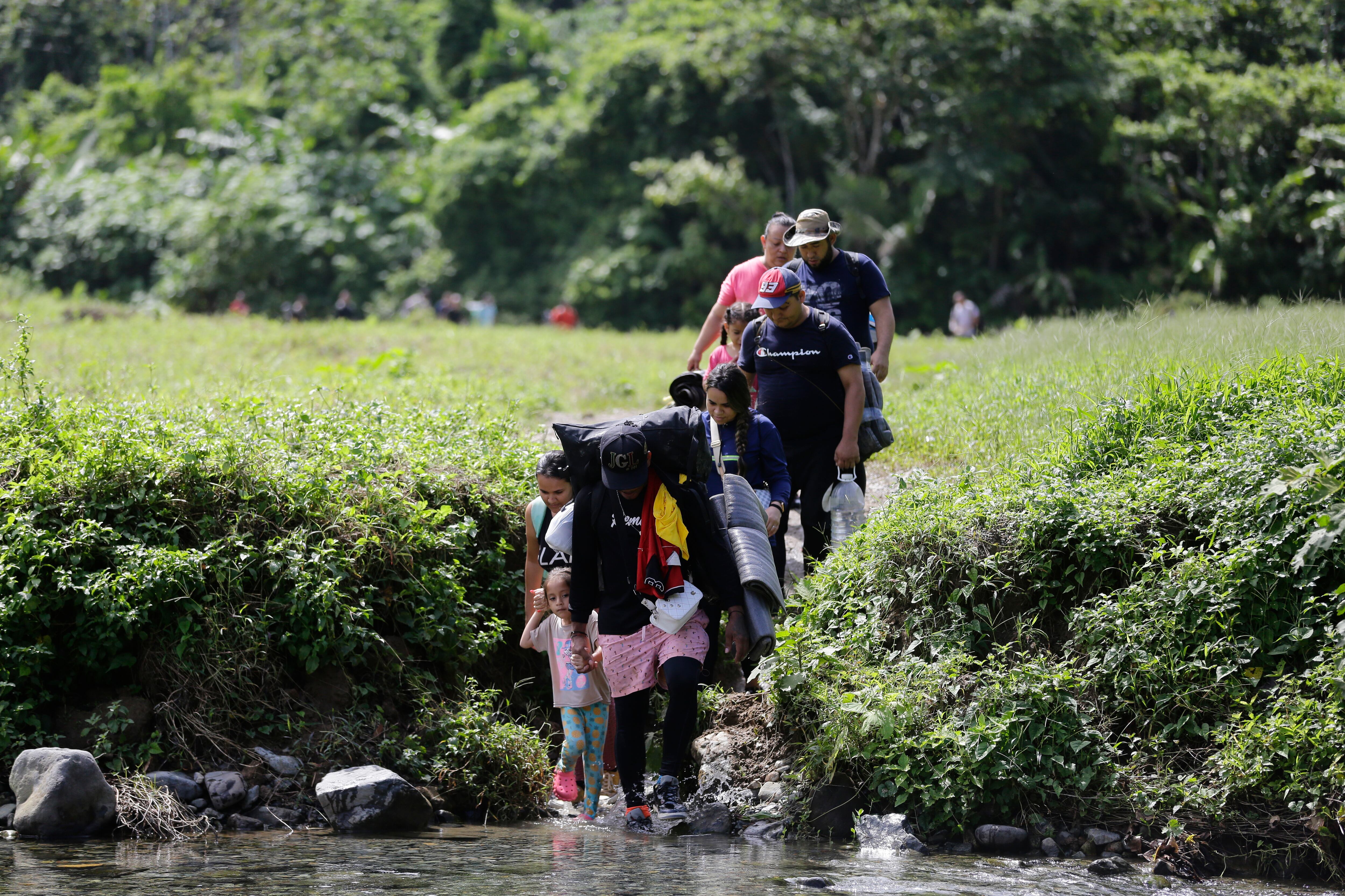Migrantes acompañados con niños pequeños mientras caminan en el sector de Cañas Blancas en Darién (Panamá). Foto: EFE / Carlos Lemos / ARCHIVO
