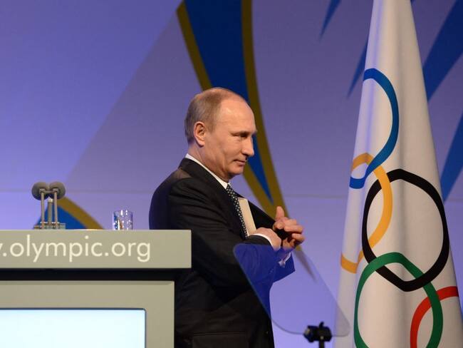 Presidente de Rusia, Vladimir Putin, y la bandera del Comité Olímpico Internacional (Photo by ANDREJ ISAKOVIC / POOL / AFP) (Photo by ANDREJ ISAKOVIC/POOL/AFP via Getty Images)