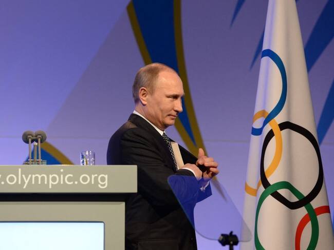 Presidente de Rusia, Vladimir Putin, y la bandera del Comité Olímpico Internacional (Photo by ANDREJ ISAKOVIC / POOL / AFP) (Photo by ANDREJ ISAKOVIC/POOL/AFP via Getty Images)