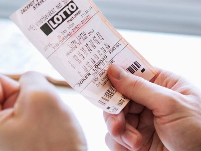 Foto ilustrativa de una persona con un billete de lotería. Foto: Getty Images/Maskot
