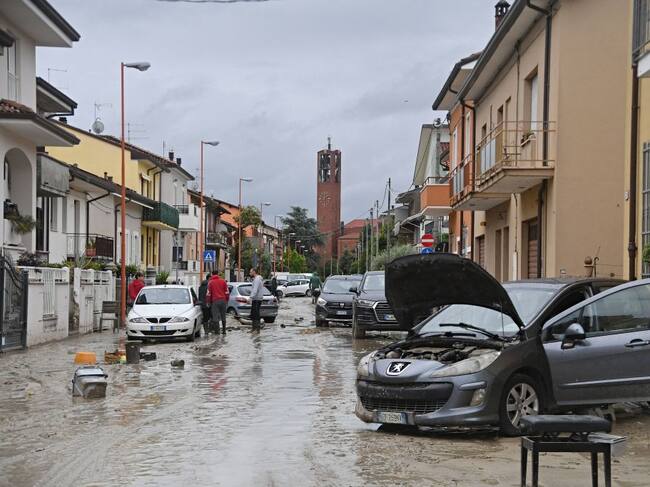 Local residents observe the aftermath of a flooding in a street of the San Rocco district of Cesena on May 17, 2023. Heavy rains have caused major floodings in central Italy, where trains were stopped and schools were closed in many towns while people were asked to leave the ground floors of their homes and to avoid going out. Five people have died after the floodings across Italy's northern Emilia Romagna region, a local official said. (Photo by Alessandro SERRANO / AFP) (Photo by ALESSANDRO SERRANO/AFP via Getty Images)