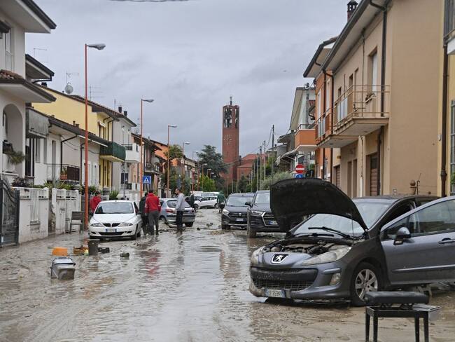 Local residents observe the aftermath of a flooding in a street of the San Rocco district of Cesena on May 17, 2023. Heavy rains have caused major floodings in central Italy, where trains were stopped and schools were closed in many towns while people were asked to leave the ground floors of their homes and to avoid going out. Five people have died after the floodings across Italy's northern Emilia Romagna region, a local official said. (Photo by Alessandro SERRANO / AFP) (Photo by ALESSANDRO SERRANO/AFP via Getty Images)