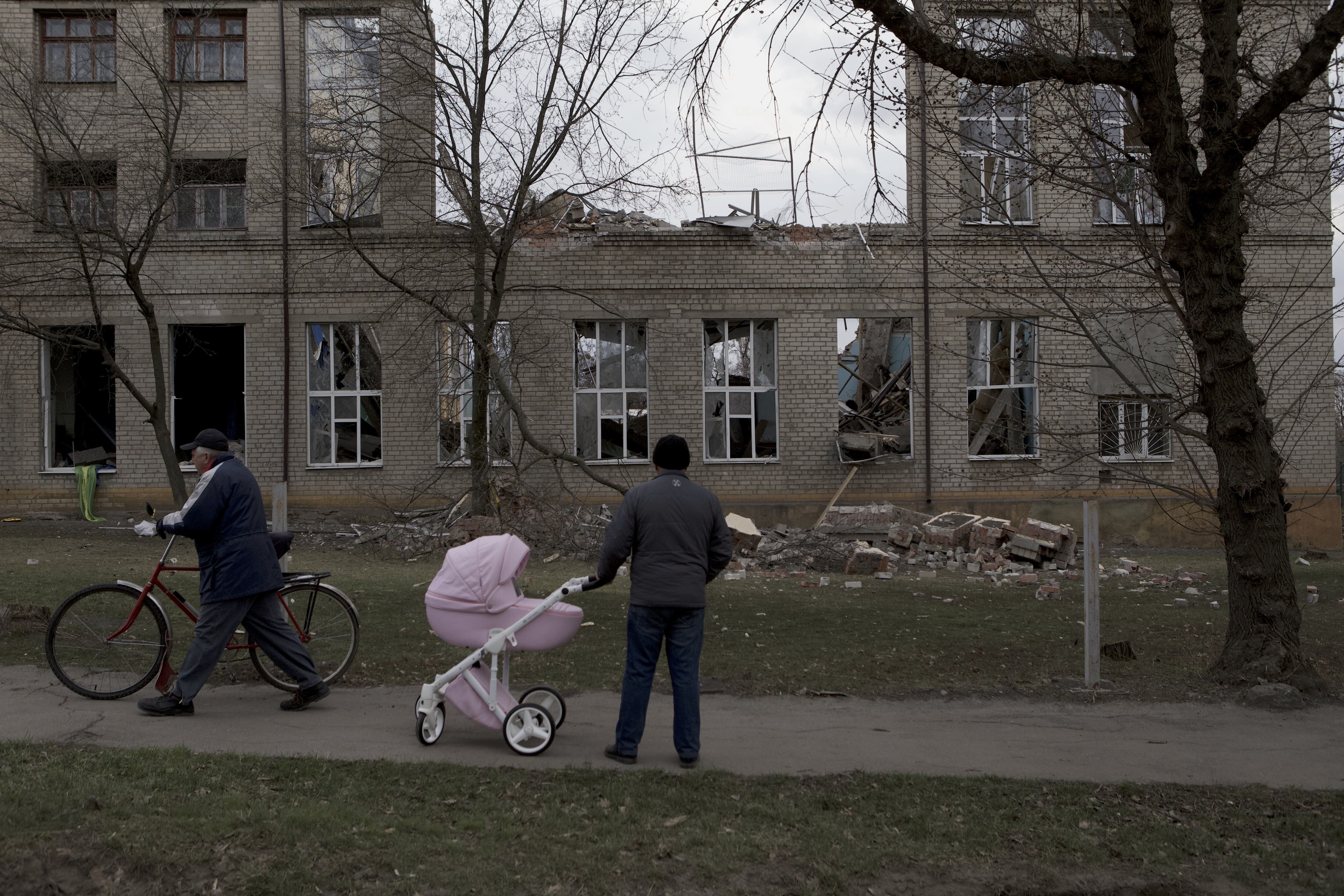 KRAMATORSK, UKRAINE - APRIL 5: People passing by a destroyed school building hit by a bomb in Kramatorsk, Donetsk Oblast, in eastern Ukraine on April 5, 2022. (Photo by Andrea Carrubba/Anadolu Agency via Getty Images)