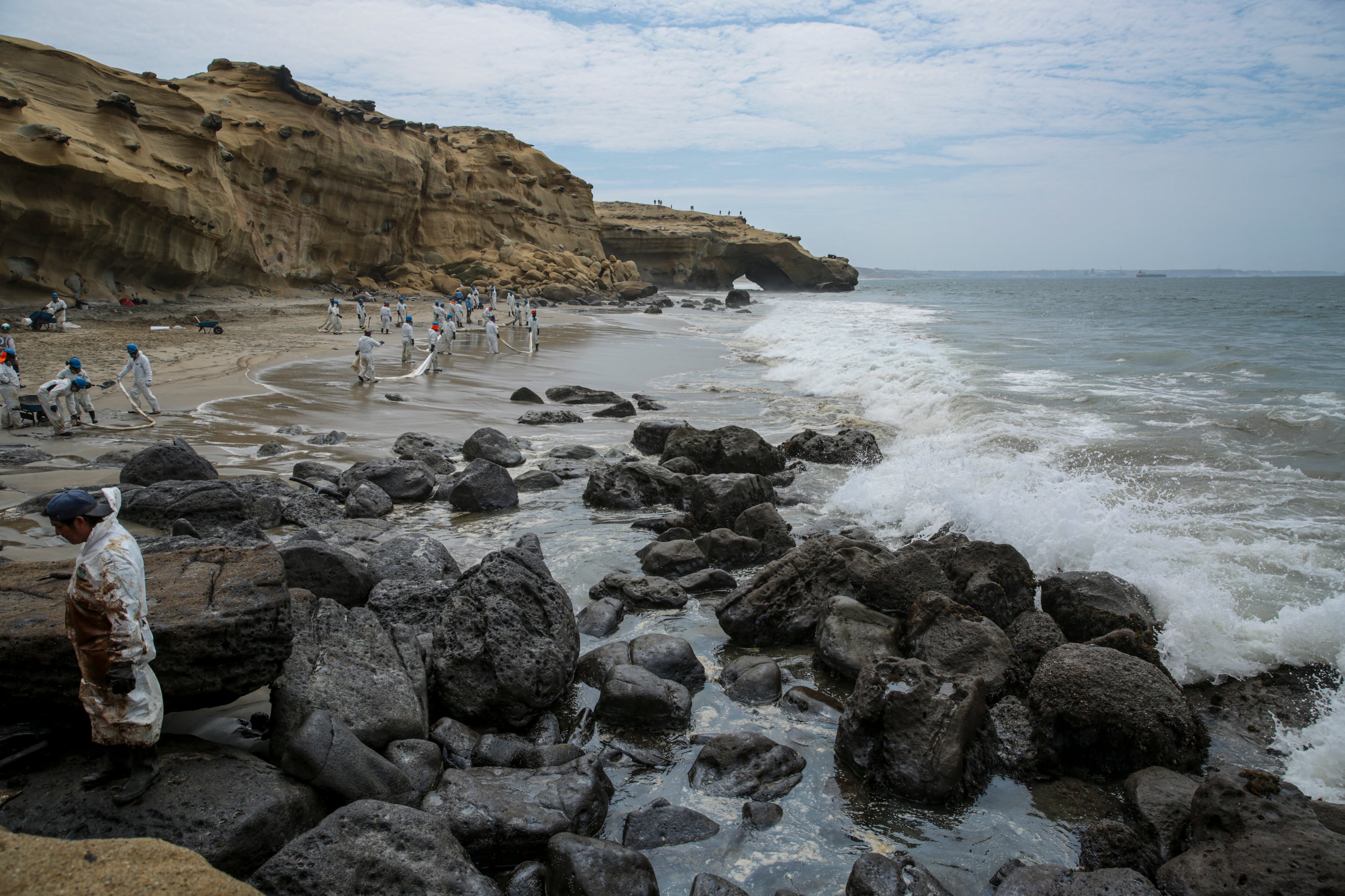 Foto difundida por la ONG Coast 2 Coast Movement que muestra a trabajadores limpiando la playa Las Capullanas tras un vertido de petróleo en Lobitos, Piura, norte de Perú, el 22 de diciembre de 2024. Coast to Coast Movement / AFP