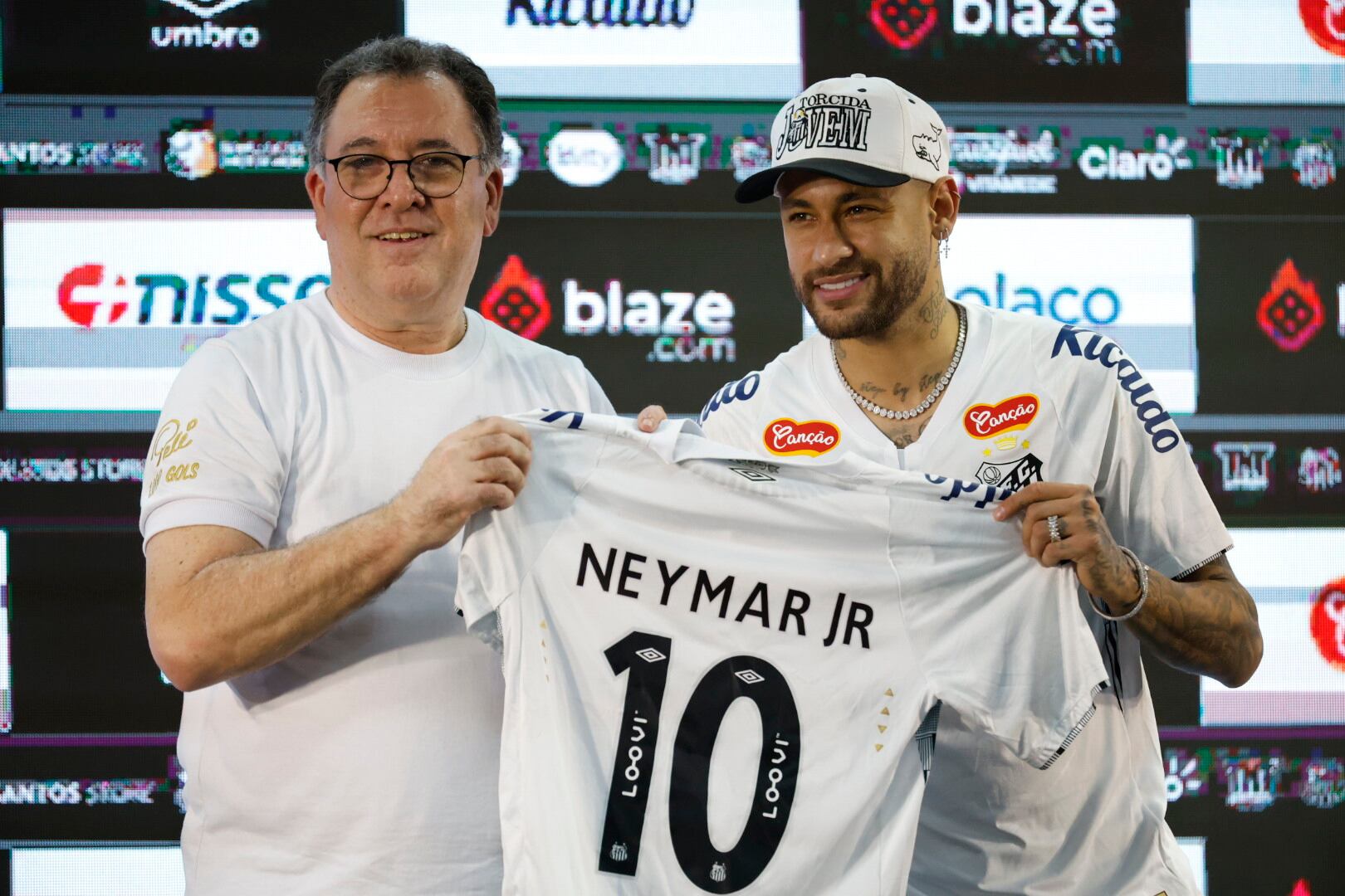 AME5596. SANTOS (BRASIL), 31/01/2025.- El presidente del Santos, Marcelo Teixeira (i), presenta al delantero brasileño Neymar como nuevo jugador del club este miércoles, durante una rueda de prensa en el estadio Vila Belmiro, en la ciudad de Santos (Brasil). Neymar está de vuelta en casa. El delantero brasileño se presentó oficialmente con el Santos ante miles de aficionados que transformaron el estadio Vila Belmiro en una gran fiesta y emocionaron a su nuevo 10, a pesar de la lluvia. EFE/ Sebastiao Moreira