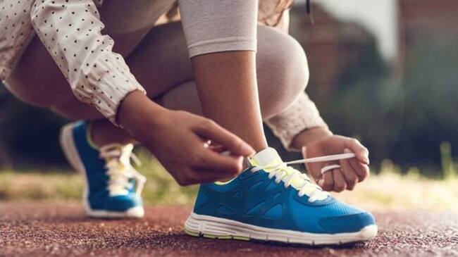 Joven atándose los cordones. Foto: Getty Images