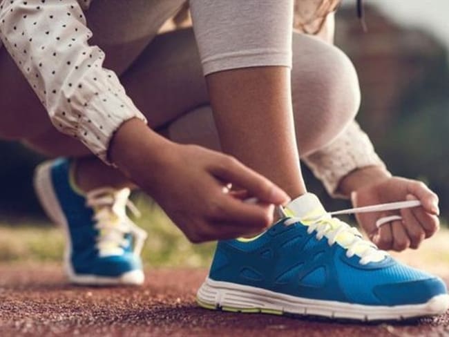 Joven atándose los cordones. Foto: Getty Images