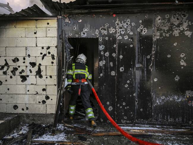 A firefighter enters a house to extinguish a fire after shelling on the 17th day of the Russian invasion of Ukraine, in Kyiv on March 12, 2022. - Russian forces are positioned around Kiev on March 12, 2022 and are &quot;blocking&quot; Mariupol, where thousands of people are suffering a devastating siege, in southern Ukraine, a country that has been bombed for more than two weeks. (Photo by Aris Messinis / AFP) (Photo by ARIS MESSINIS/AFP via Getty Images)