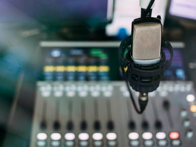 Close up of microphone on radio broadcast studio and sound mixing console on the background
