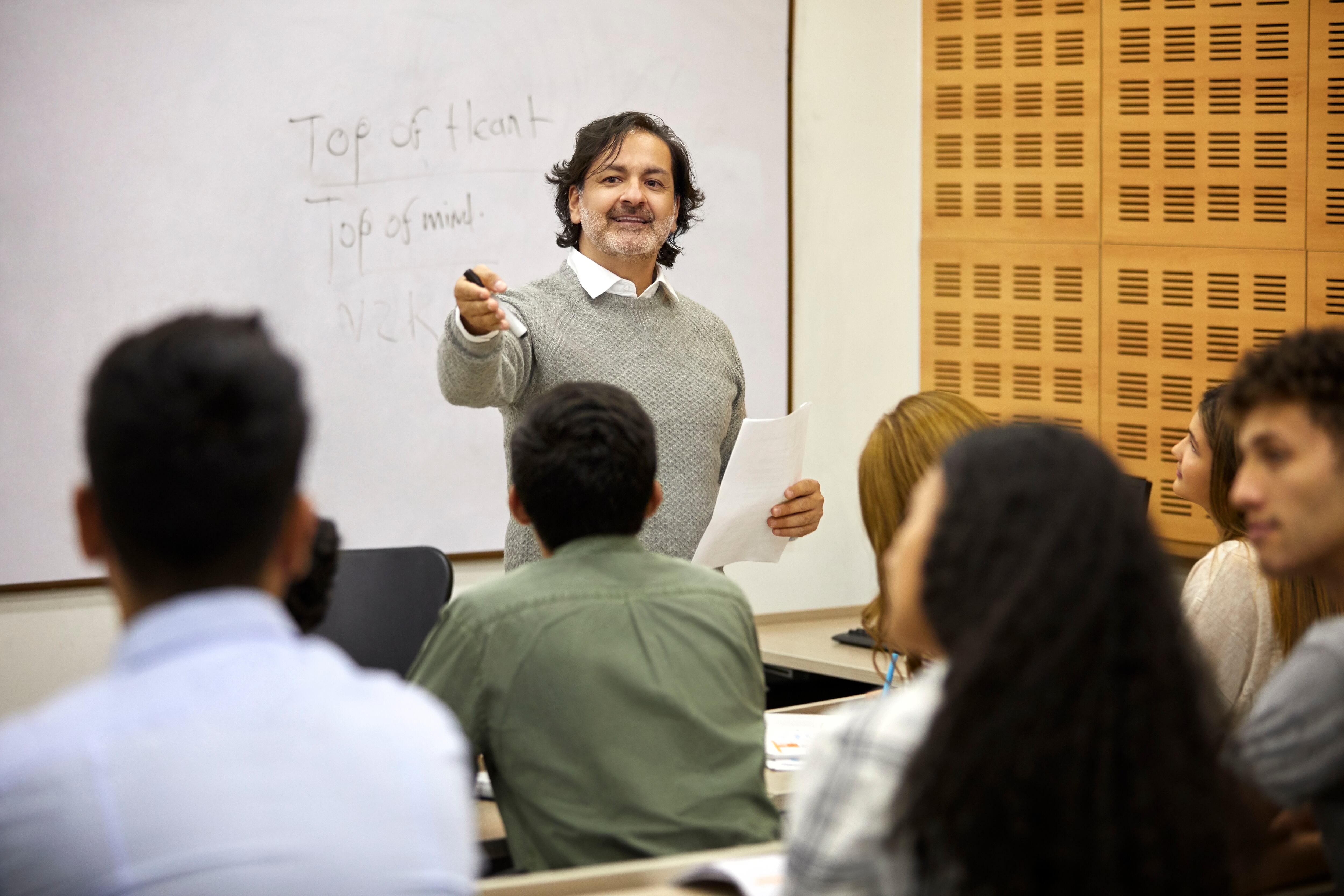 Profesor haciendo preguntas en una clase con estudiantes (GettyImages)