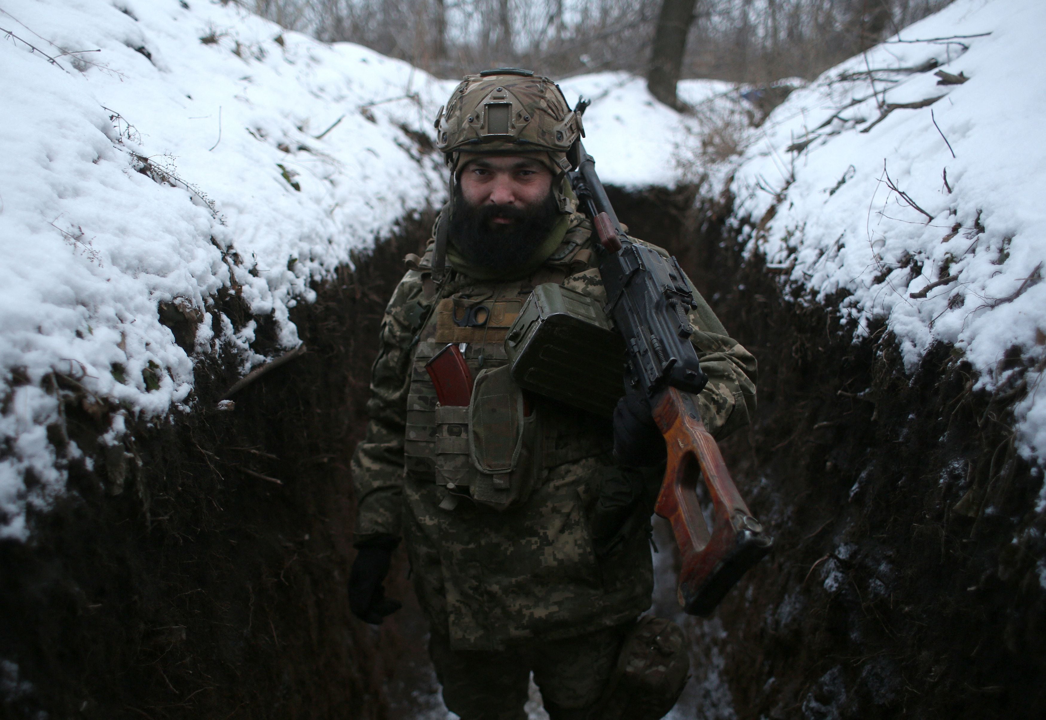 An Ukrainian Military Forces serviceman poses with his weapons in a trench on the frontline with the Russia-backed separatists near Zolote village, in the eastern Lugansk region, on January 21, 2022. - Ukraine's Foreign Minister Dmytro Kuleba on January 22, 2022, slammed Germany for its refusal to supply weapons to Kyiv, urging Berlin to stop "undermining unity" and "encouraging Vladimir Putin" amid fears of a Russian invasion. (Photo by Anatolii STEPANOV / AFP) (Photo by ANATOLII STEPANOV/AFP via Getty Images)