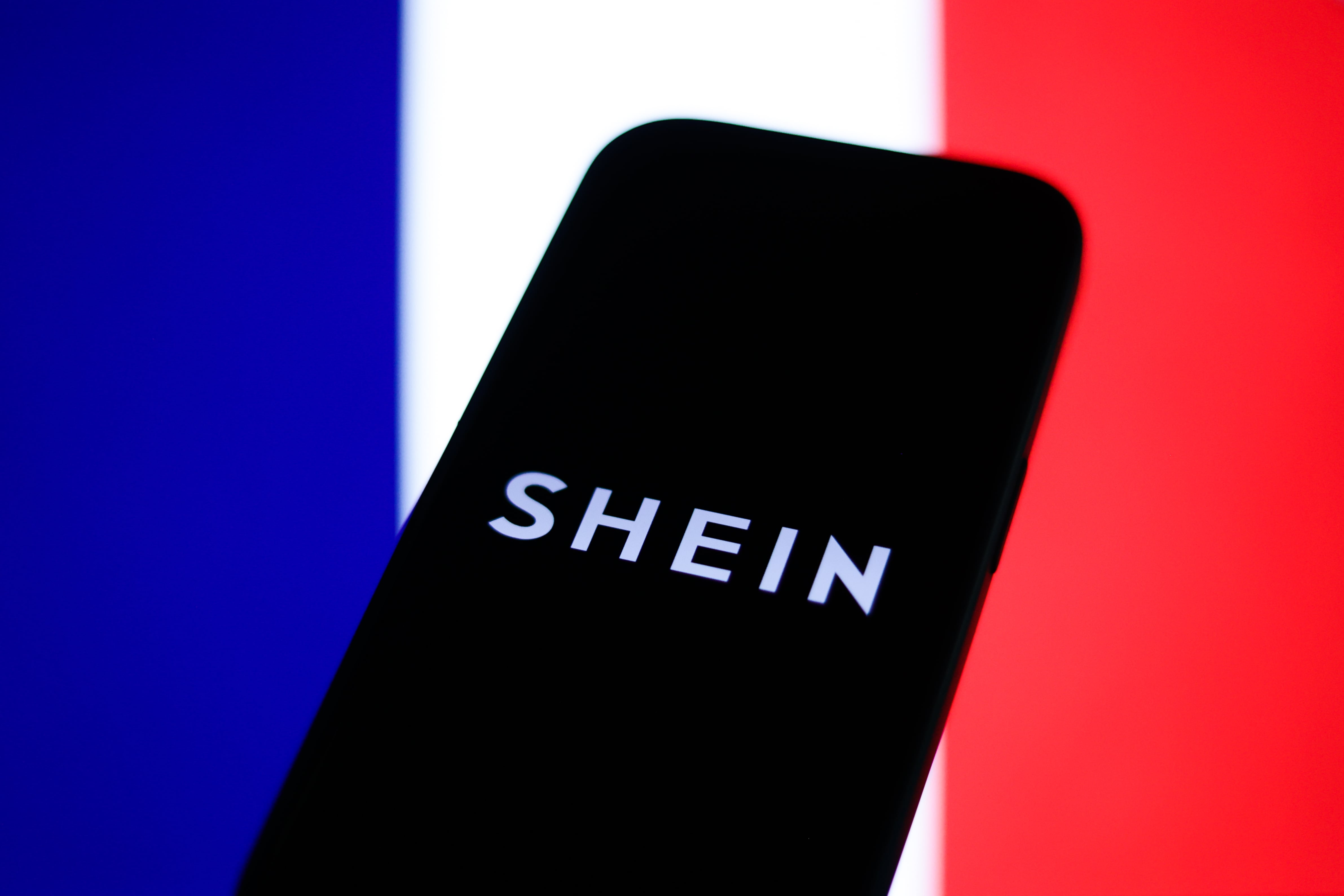 Bandera de Francia y logo de Shein. FOTO: Jakub Porzycki/Getty Images
