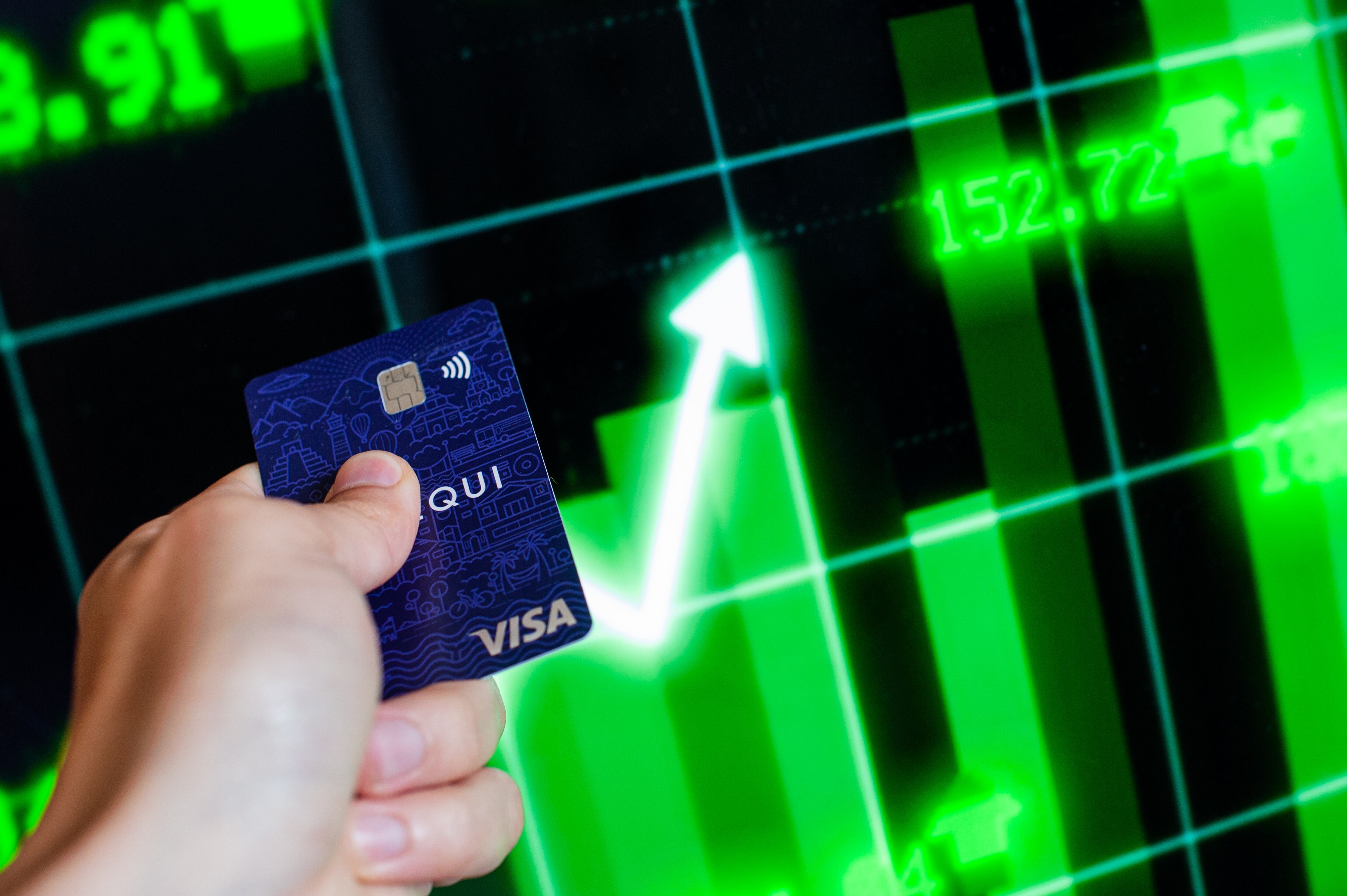 Una tarjeta bancaria NEQUI frente a una flecha verde de la bolsa. (Sebastian Barros/NurPhoto vía Getty Images)
