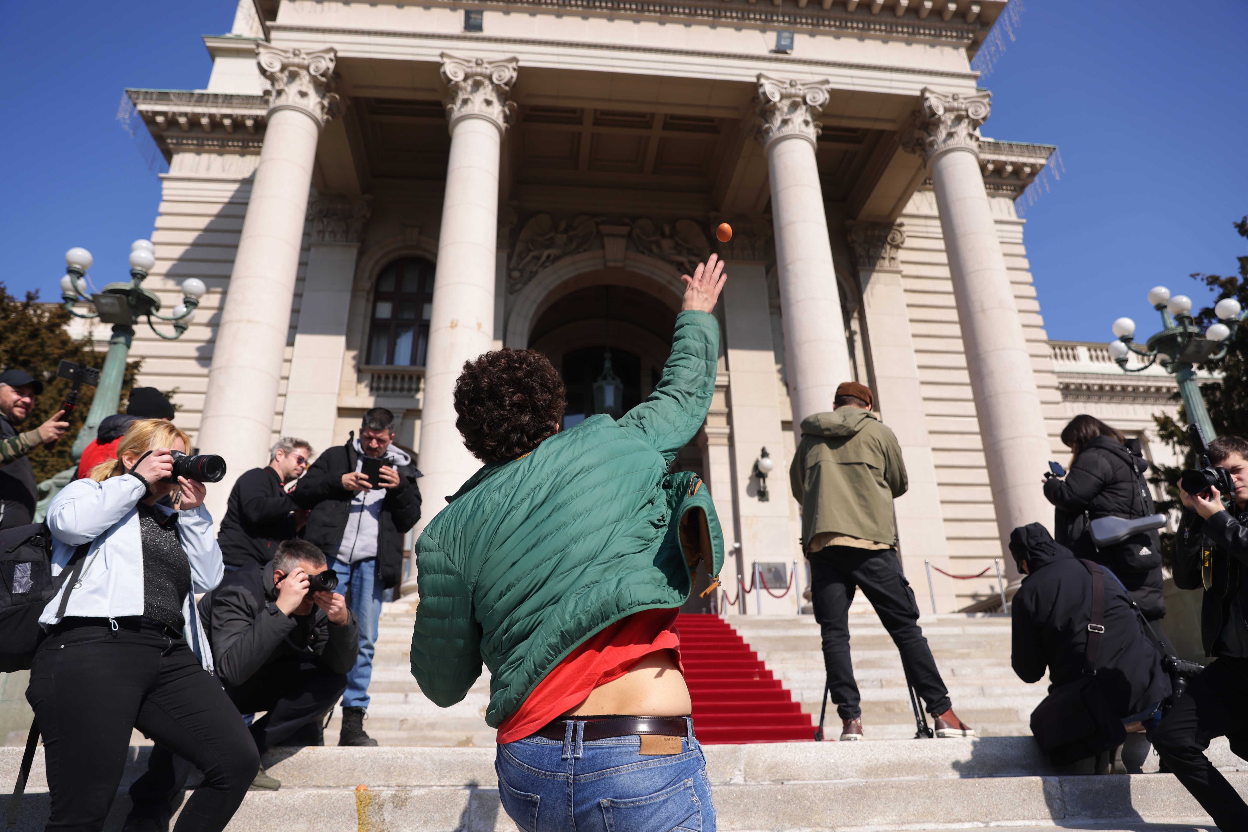 Manifestante lanzando huevos al edificio del parlamento serbio. FOTO: EFE/EPA/ANDREJ CUKIC.