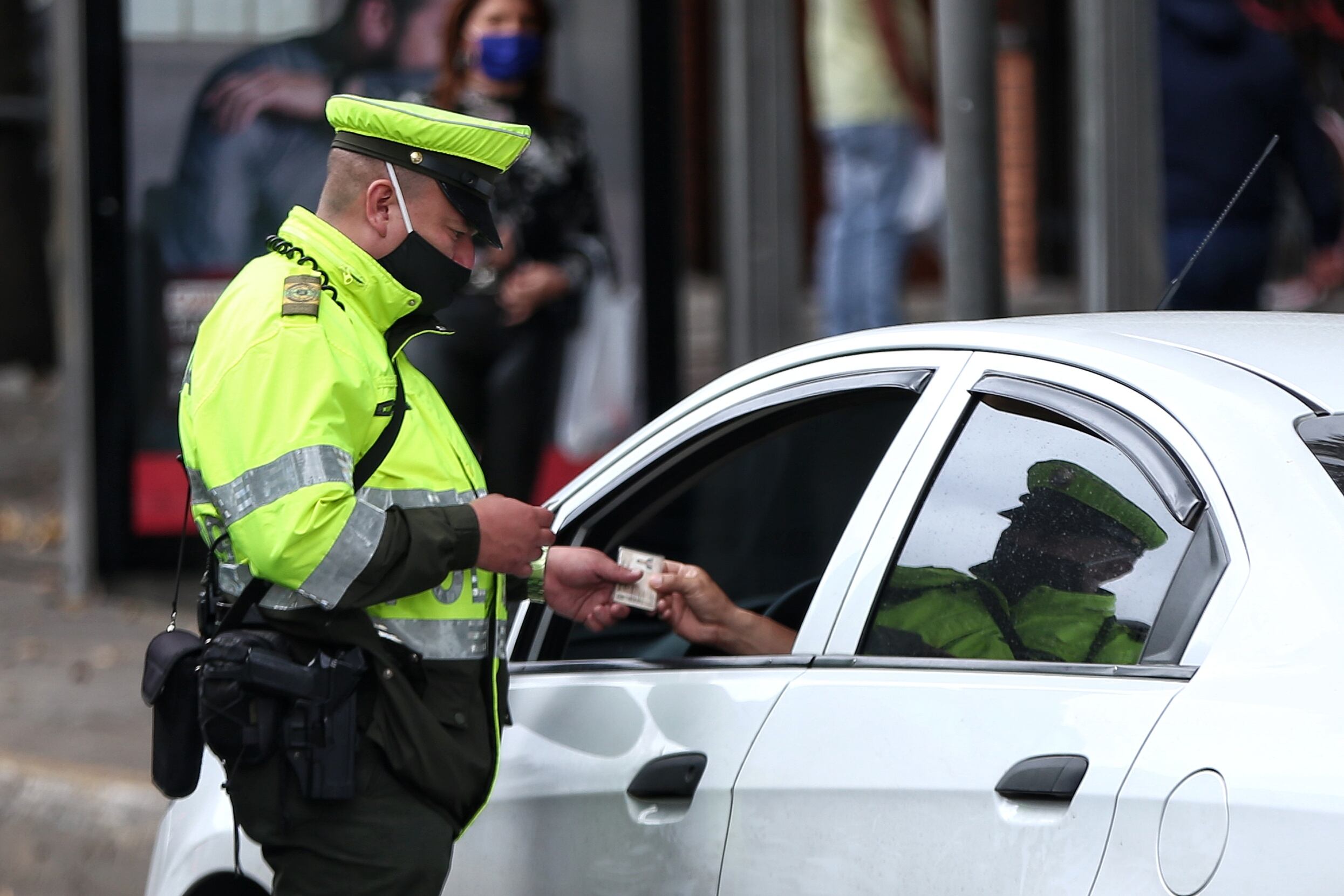 Uniformado de la Policía revisando los documentos de un colombiano (Foto vía Colprensa)