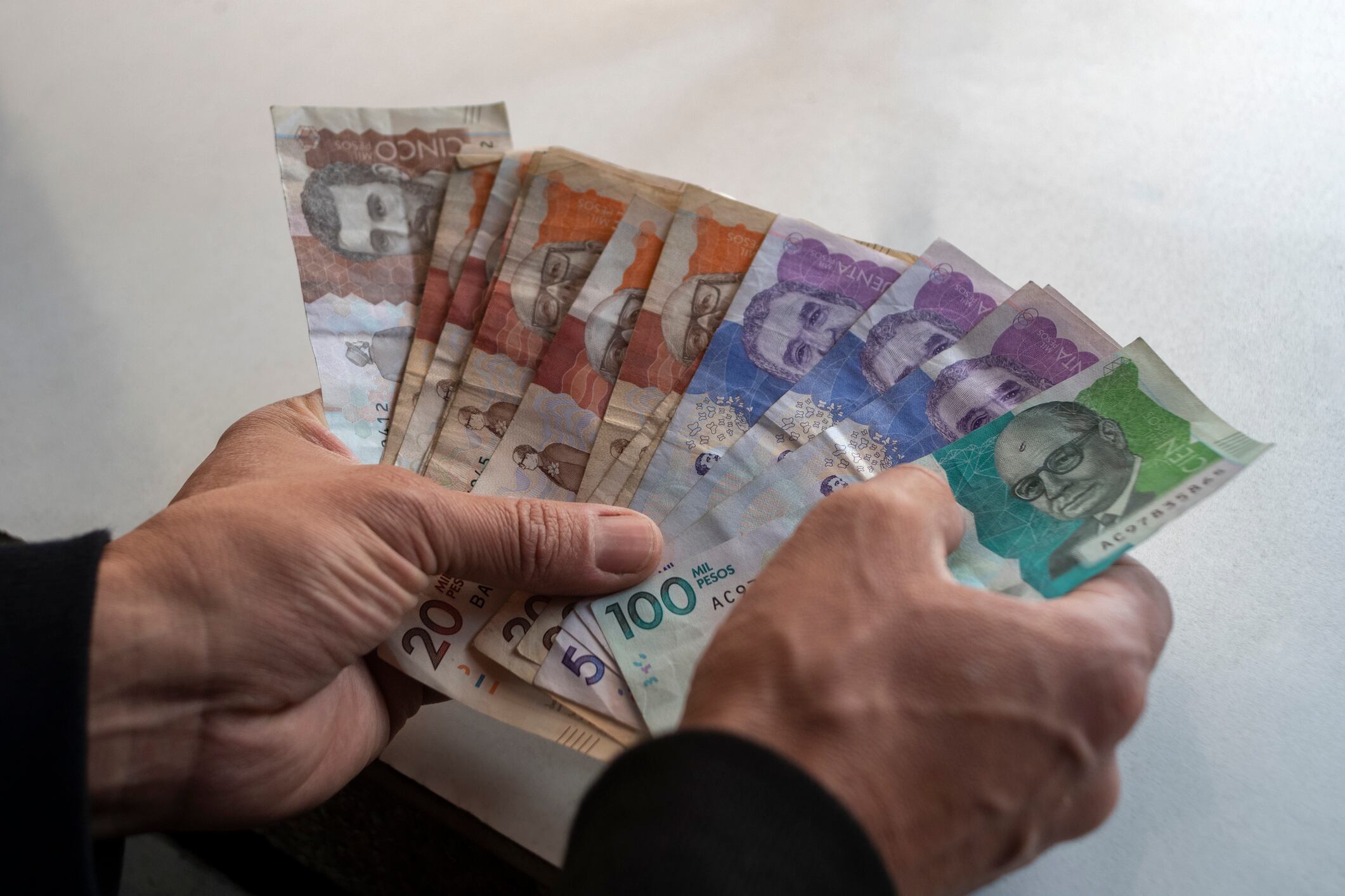 Men's hands with Colombian Pesos