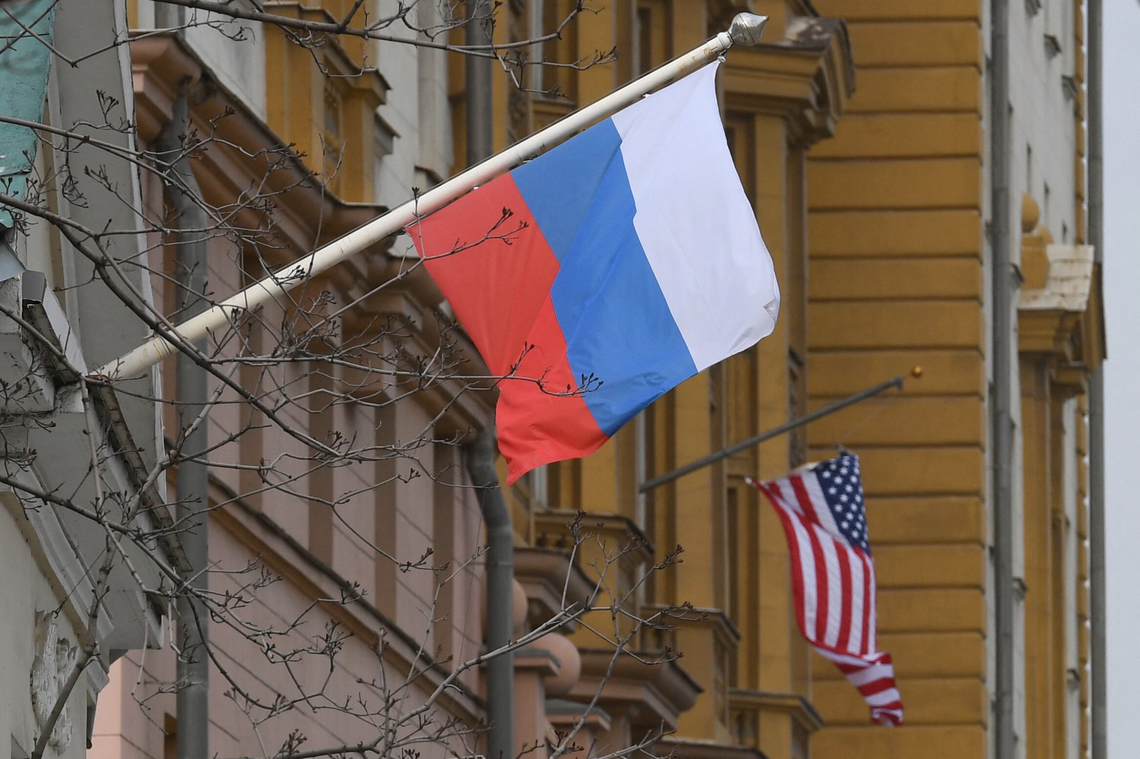 A Russian flag flies next to the US embassy building in Moscow on April 15, 2021. - The United States announced economic sanctions against Russia on April 15, 2021 and the expulsion of 10 diplomats in retaliation for what Washington says is the Kremlin's US election interference, a massive cyber attack and other hostile activity. (Photo by NATALIA KOLESNIKOVA / AFP) (Photo by NATALIA KOLESNIKOVA/AFP via Getty Images)
