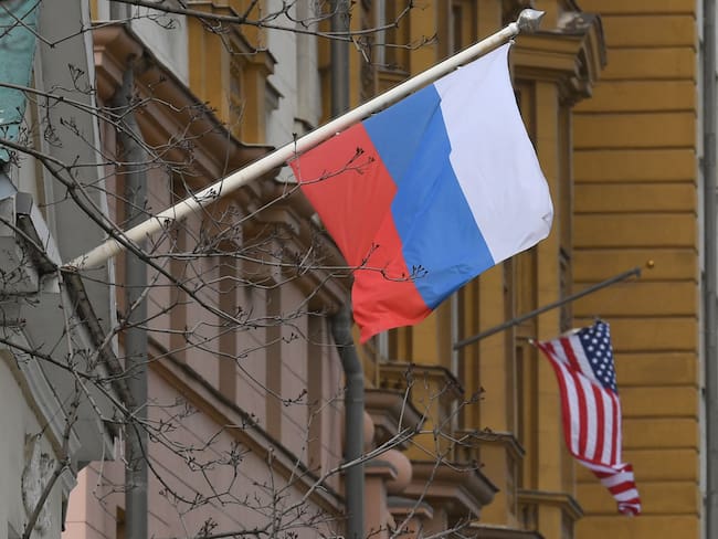 A Russian flag flies next to the US embassy building in Moscow on April 15, 2021. - The United States announced economic sanctions against Russia on April 15, 2021 and the expulsion of 10 diplomats in retaliation for what Washington says is the Kremlin&#039;s US election interference, a massive cyber attack and other hostile activity. (Photo by NATALIA KOLESNIKOVA / AFP) (Photo by NATALIA KOLESNIKOVA/AFP via Getty Images)