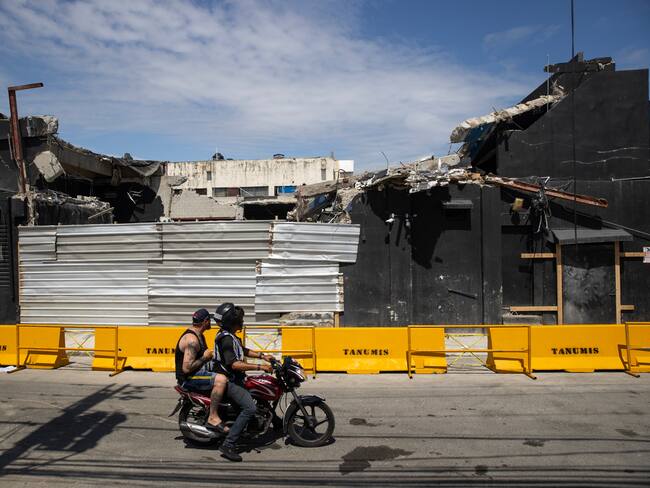 AME8295. SANTO DOMINGO (REPÚBLICA DOMINICANA), 11/04/2025.- Personas pasan frente a uno de los accesos a la discoteca Jet Set este viernes, en Santo Domingo (República Dominicana). Cuatro días después de que se desplomara el techo de la discoteca Jet Set en Santo Domingo causando el fallecimiento de 221 personas, toda República Dominicana está de luto y entierra a los muertos de una tragedia cuyas causas estudiará y determinará una comisión de expertos. EFE/ Orlando Barría