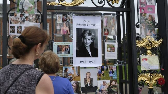 Turistas observan homenajes y recuerdos de la difunta Diana, princesa de Gales, colocados afuera del Palacio de Kensington en Londres. Foto: Associated Press - AP