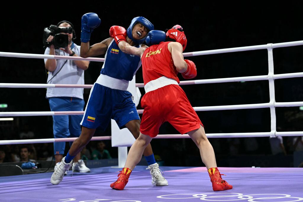 China's Zichun Xu (in red) fights against Colombia's Valeria Arboleda Mendoza (in blue) in the women's 57kg preliminaries round of 16 boxing match during the Paris 2024 Olympic Games at the North Paris Arena, in Villepinte on August 2, 2024. (Photo by MOHD RASFAN / AFP) (Photo by MOHD RASFAN/AFP via Getty Images)