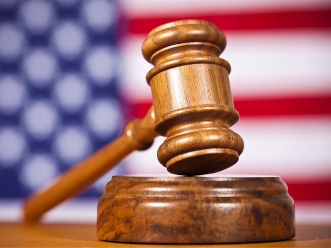 A Wooden Gavel In Front Of An American Flag