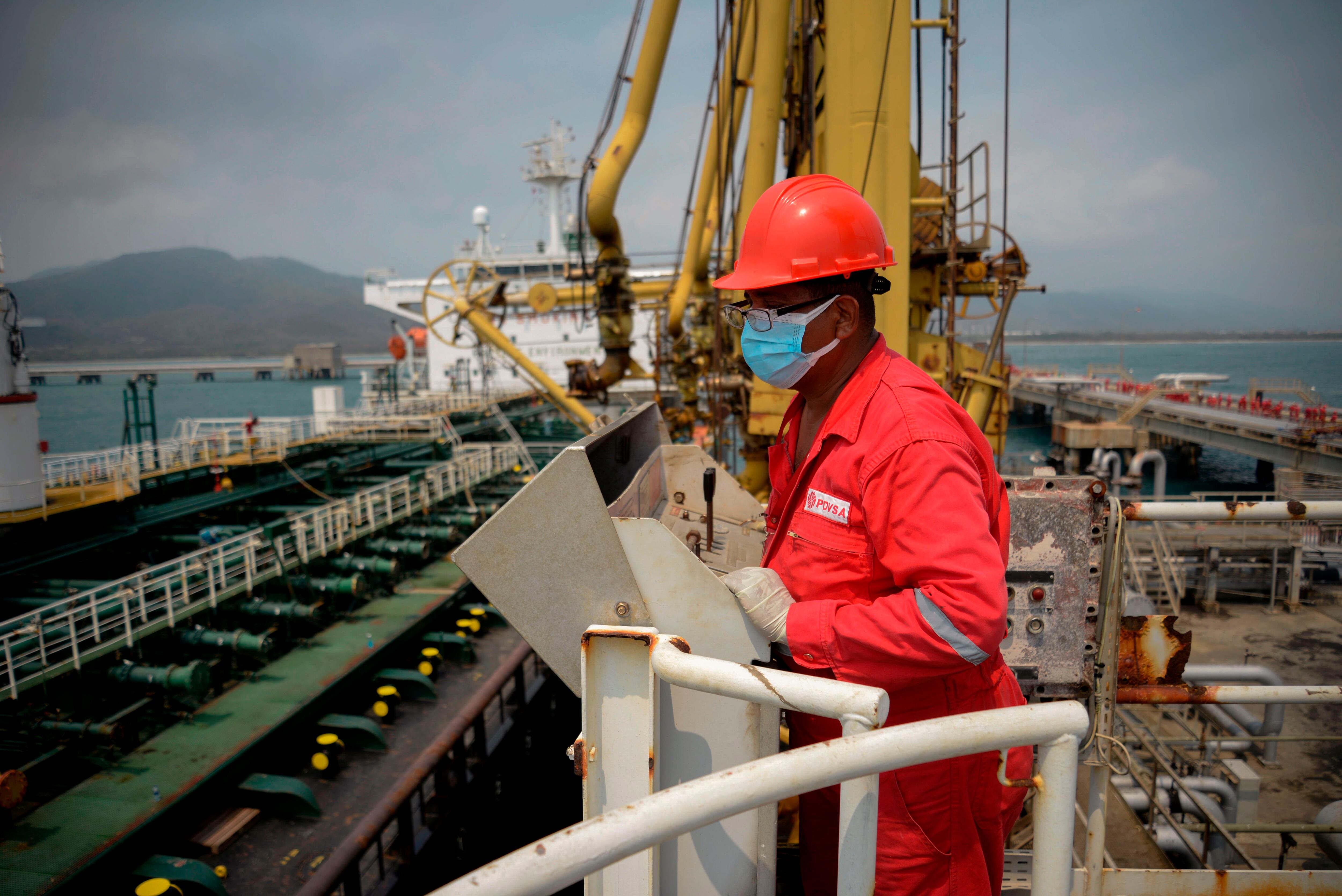 A worker of the Venezuelan state oil company PDVSA looks at the Iranian-flagged oil tanker Fortune as it docks at the El Palito refinery in Puerto Cabello in the northern state of Carabobo, Venezuela, on May 25, 2020. - The first of five Iranian tankers carrying much-needed gasoline and oil derivatives docked in Venezuela on Monday, Caracas announced amid concern in Washington over the burgeoning relationship between countries it sees as international pariahs. (Photo by - / AFP) (Photo by -/AFP via Getty Images)