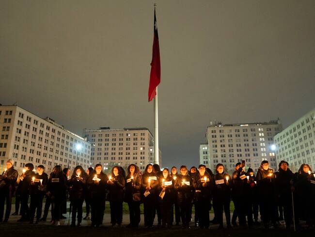AME8547. SANTIAGO (CHILE), 10/09/2023.- Mujeres participan hoy de la velatón en conmemoración de los 50 años del golpe de estado contra el gobierno democrático de Salvador Allende, en Santiago (Chile). Miles de personas marcharon hoy por las calles de Santiago de Chile con miles de fotos alzadas al cielo gris de compatriotas y familiares asesinados o detenidos desaparecidos en la manifestación anual en memoria del golpe de estado del general Augusto Pinochet contra el gobierno democrático del socialista Salvador Allende, del que este 11 de septiembre se cumplen 50 años. EFE/ Adriana Thomasa