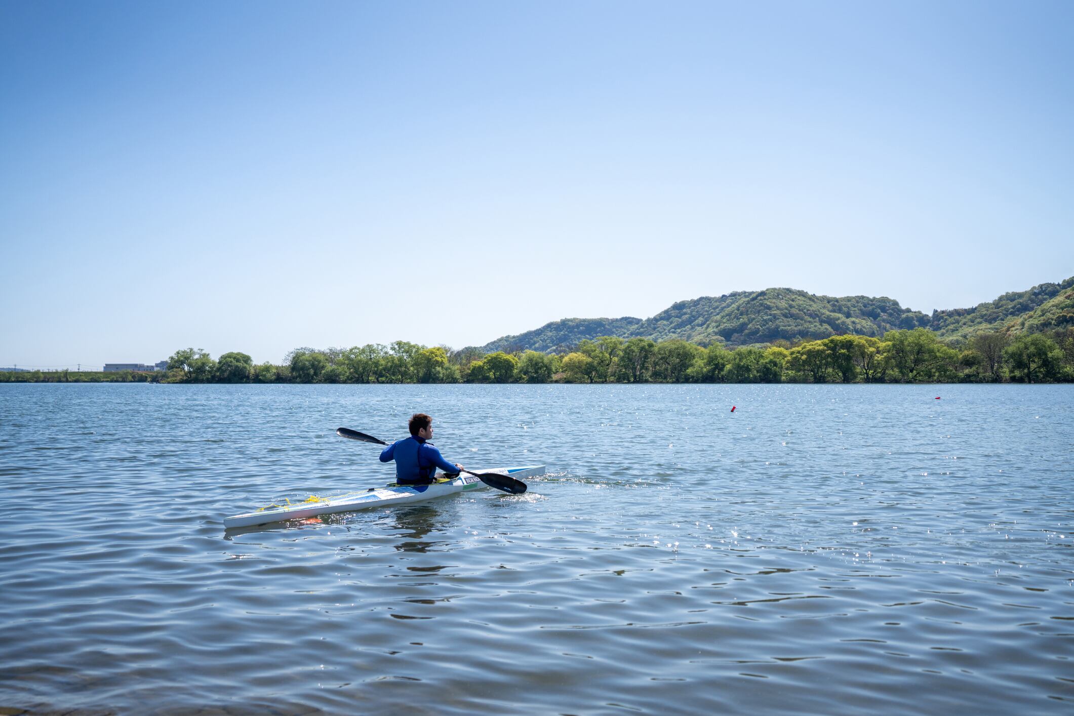 Paracanoe athlete in his kayak on the water during a training session in Japan