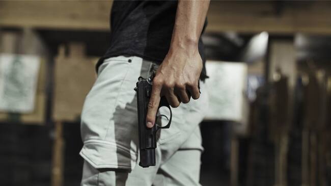 Imagen de referencia de un hombre portando una pistola. Foto: Getty Images / Westend61