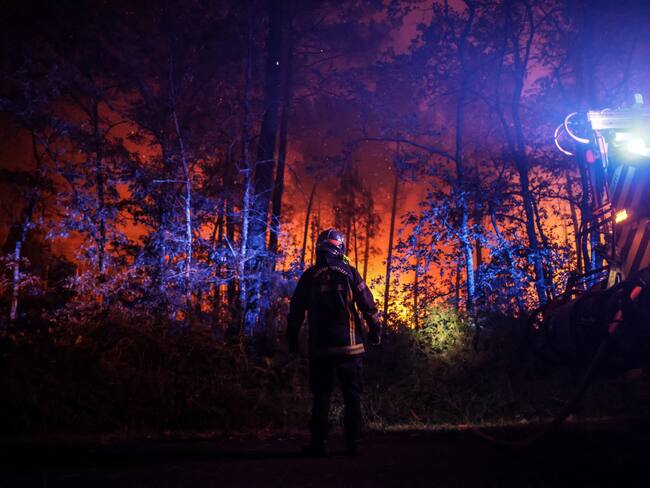 Un bombero junto a su vehículo en un incendio forestal cerca de Belin-Beliet, en el suroeste de Francia, durante la noche del 11 de agosto de 2022. (Photo by THIBAUD MORITZ/AFP via Getty Images)