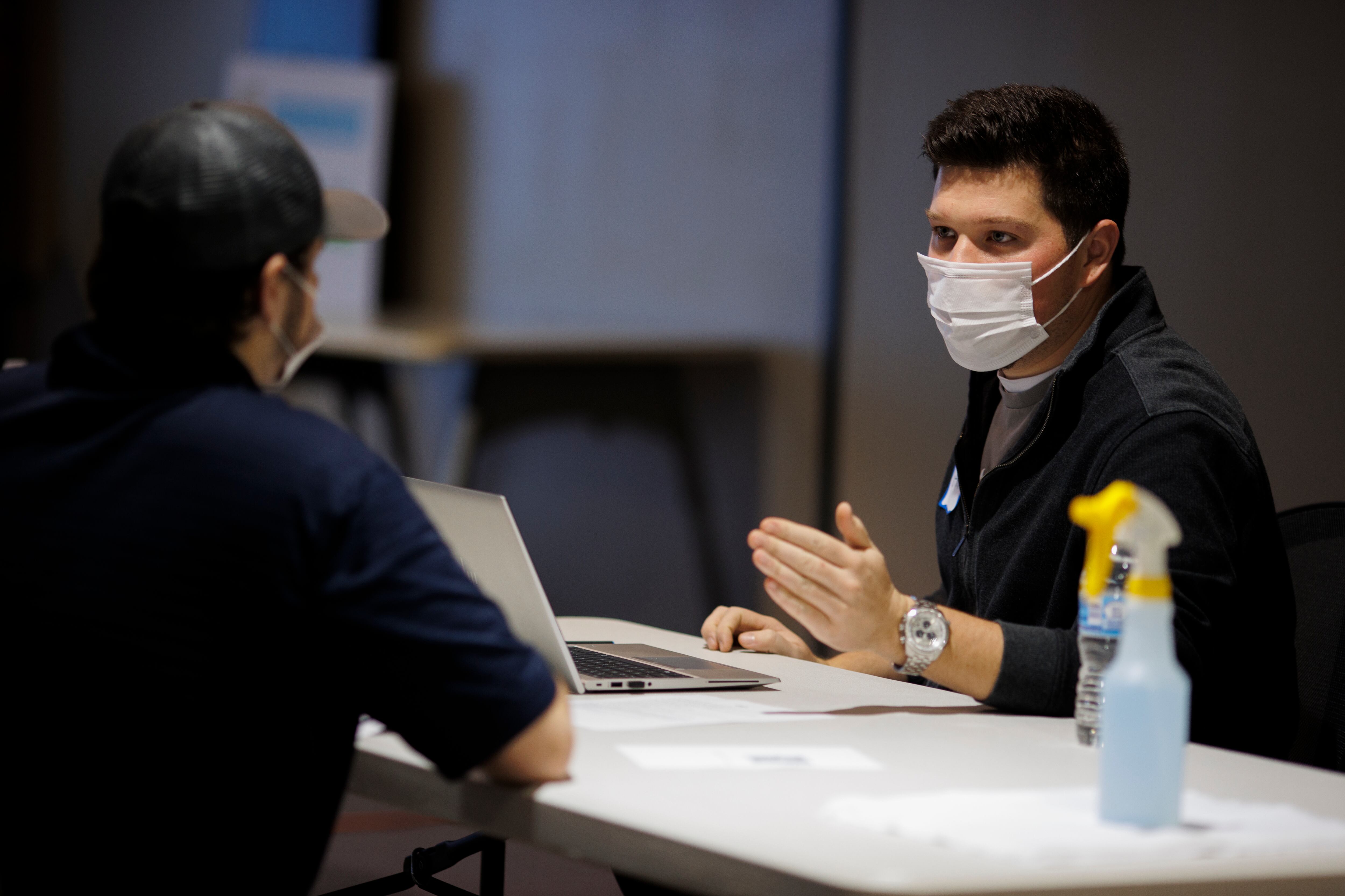 SPRING HILL, TN - NOVEMBER 16:  An applicant (left) is walked through their job offer by a General Motors employee during a job fair on November 16, 2021 in Spring Hill, Tennessee. General Motors is looking to hire 120 temporary employees to help add another shift to the engine manufacturing line at this facility. (Photo by Brett Carlsen/Getty Images)