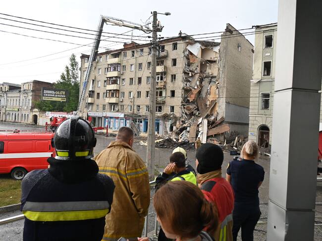 Local residents watch Ukrainian rescuers working outside a building partially destroyed after a Russian missile strike in Kharkiv on July 11, 2022, amid Russia's military invasion launched on Ukraine. (Photo by SERGEY BOBOK / AFP) (Photo by SERGEY BOBOK/AFP via Getty Images)
