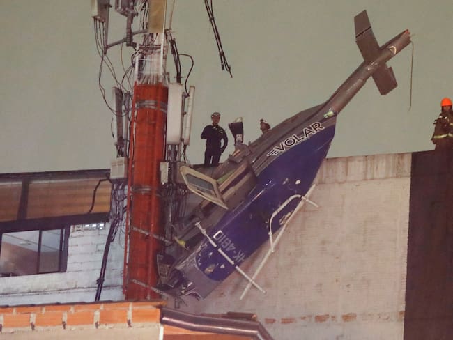MED400. MEDELLÍN (COLOMBIA), 24/02/2024.- Fotografía un helicoptero que cayó en un edificio del barrio Manrique este lunes, en Medellín (Colombia). Un helicóptero de turismo tipo Bell 206 con matrícula HK4810 se precipitó la tarde de este lunes según informó la Dirección Técnica de Investigación de Accidentes. EFE/ Luis Eduardo Noriega