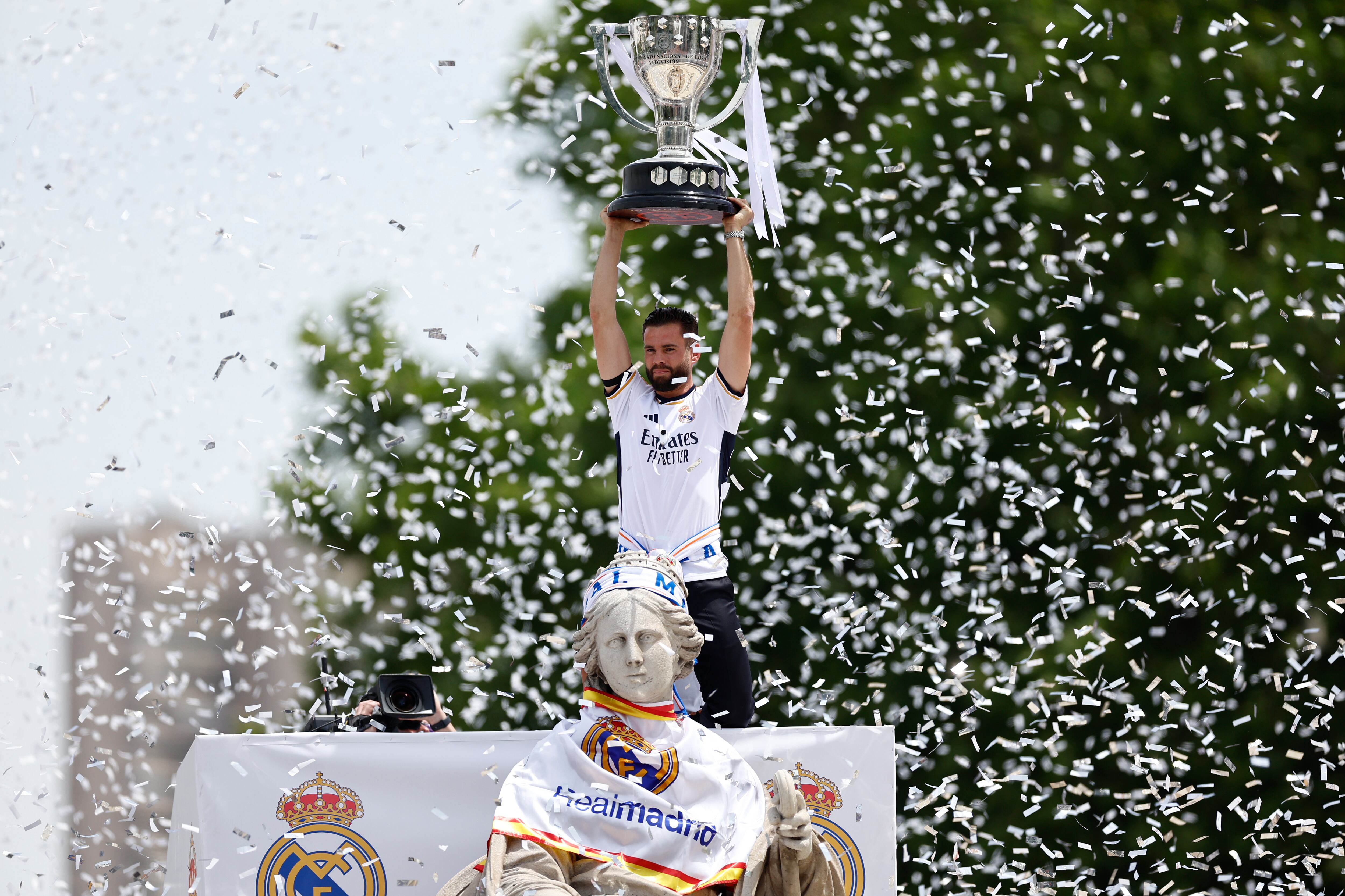 El capitán del Real Madrid, Nacho Fernández, levanta la copa junto a la diosa Cibeles durante la celebración con aficionados de la trigésimo sexta Liga, este domingo en la plaza de Cibeles. EFE/Rodrigo Jiménez