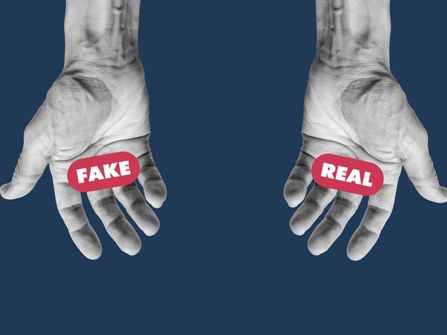 Human hands holding the words Fake and Real. Making decision concept.