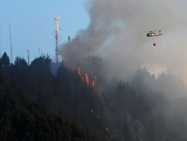 -FOTODELDÍA- BOG400. BOGOTÁ (COLOMBIA), 24/01/2024.- Un helicóptero combate hoy un incendio forestal en el cerro El Cable, en Bogotá (Colombia). Un nuevo incendio, que ahonda la crisis medioambiental en Colombia, comenzó este miércoles en los cerros orientales de Bogotá, esta vez en uno conocido como El Cable y en donde las autoridades locales tratan de apagar las llamas. EFE/ Carlos Ortega