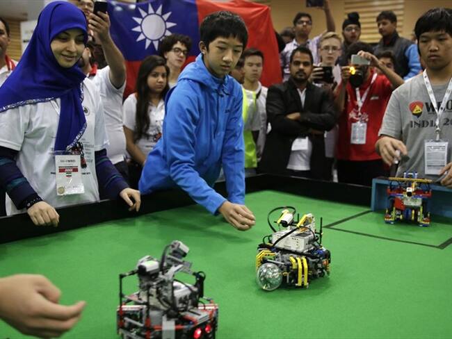 Dos adolescentes taiwaneses observan a sus robots jugar al fútbol en la Olimpíada Mundial de Robots en Nueva Delhi, India. Foto: Associated Press - AP - Tsering Topgyal