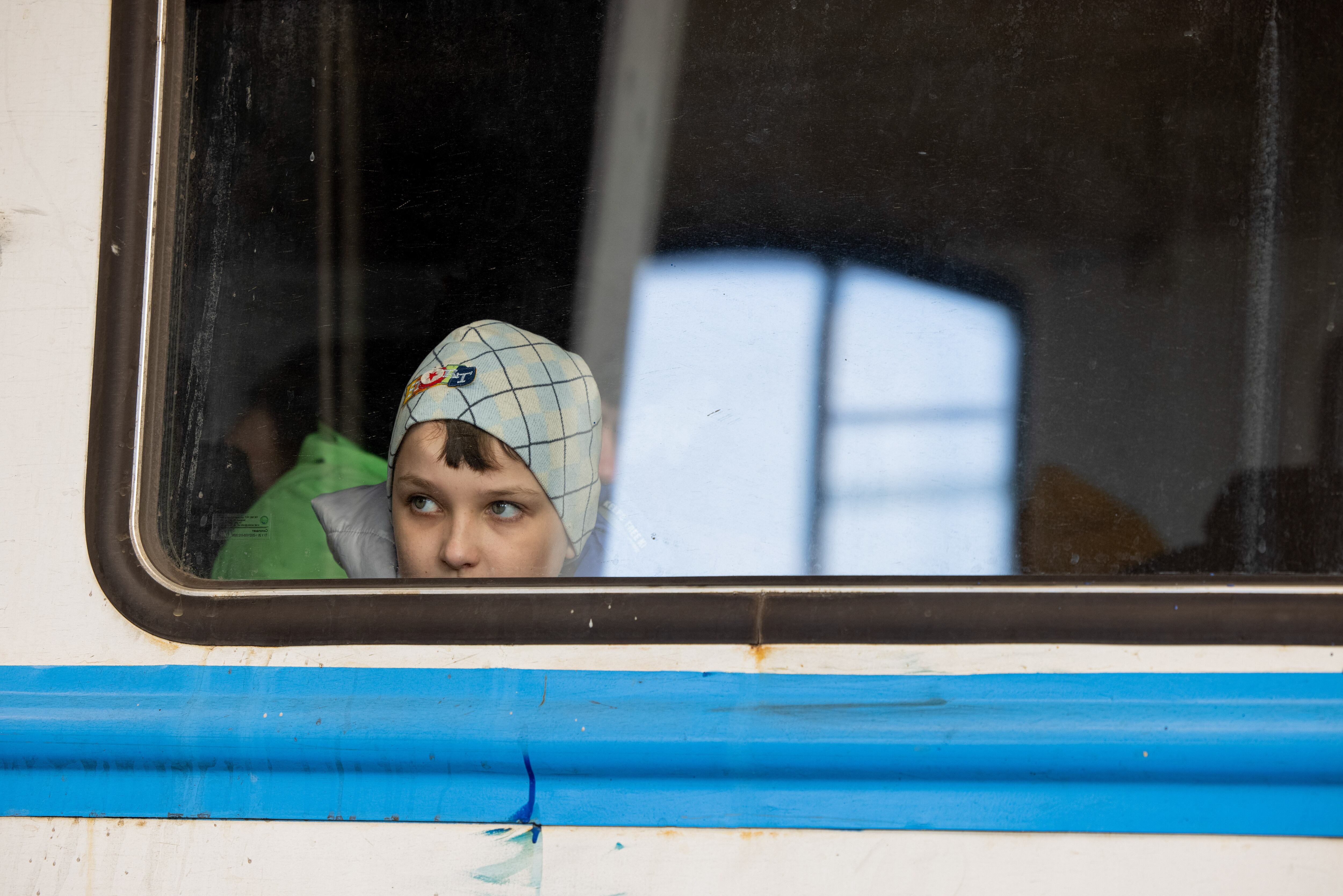 LVIV, UKRAINE - 2022/03/11: A young child in the train carriage is seen through the window at the Lviv train station. Lviv, the largest city in western Ukraine, has now become a transit hub for women and children fleeing to Europe, while men return and travel to eastern Ukraine to defend the country. (Photo by Hesther Ng/SOPA Images/LightRocket via Getty Images)