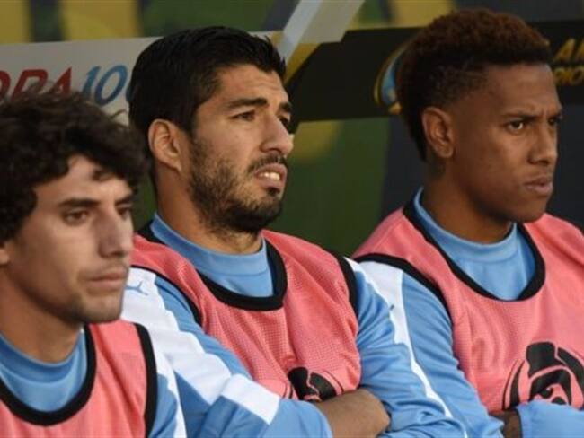 Mathias Corujo, Luis Suarez y Abel Hernandez observan los últimos minutos del encuentro ante Venezuela. Foto: AFP / BBC Mundo.