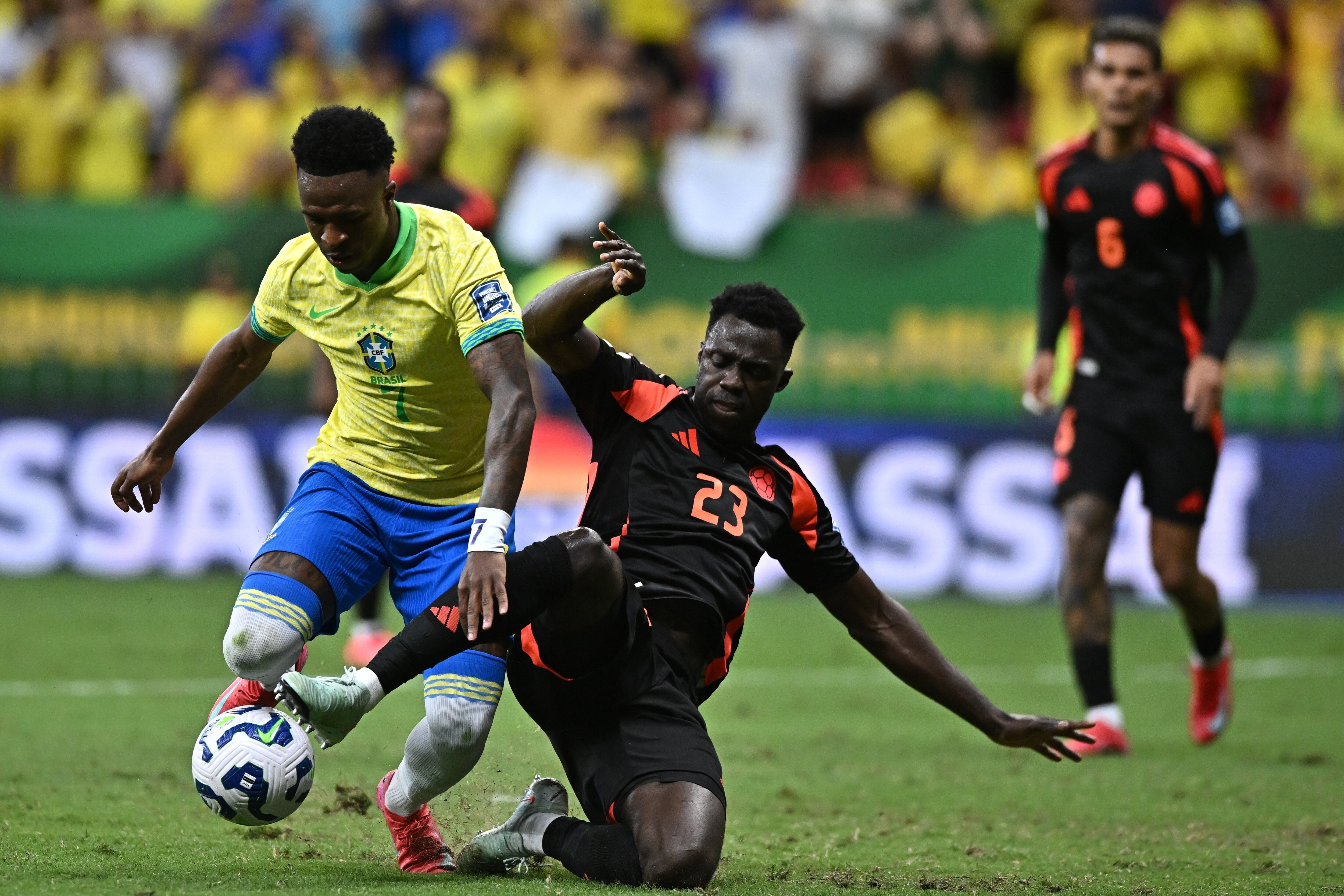 Vinicius Jr. (i) de Brasil disputa el balón con Davinson Sánchez de Colombia. Foto: EFE.