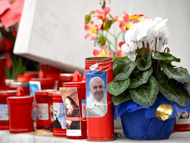 Roma (Italia), 18/02/2025.- Flores y velas son depositadas a los pies de una estatua del Papa Juan Pablo II fuera del Hospital Universitario Gemelli, donde el Papa Francisco está hospitalizado por pruebas y tratamiento de bronquitis.
