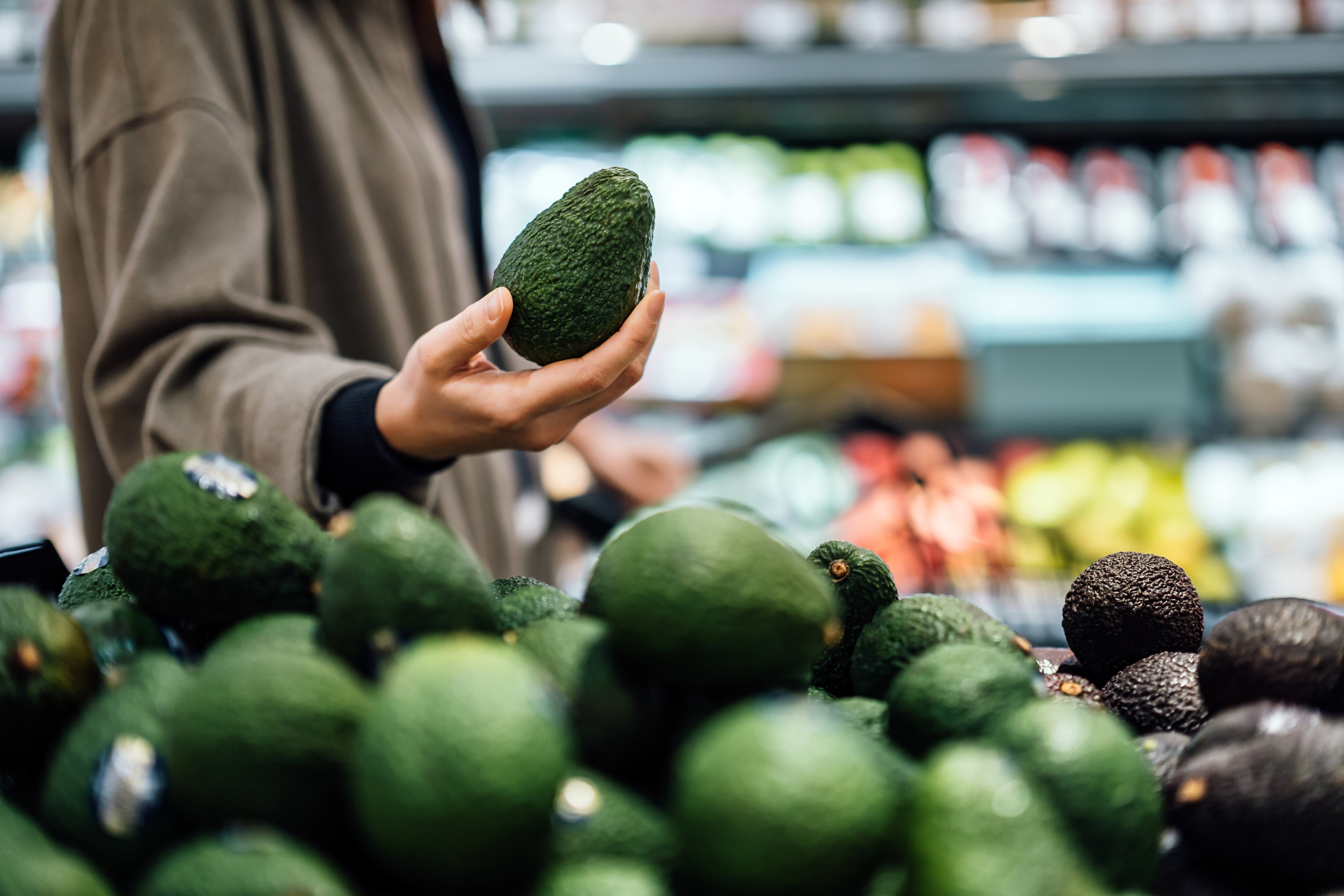 Persona eligiendo un aguacate en el supermercado (Foto vía Getty Images)