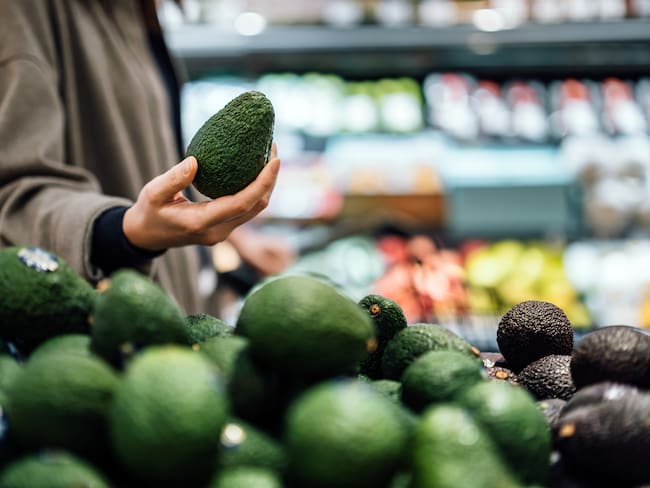 Persona eligiendo un aguacate en el supermercado (Foto vía Getty Images)