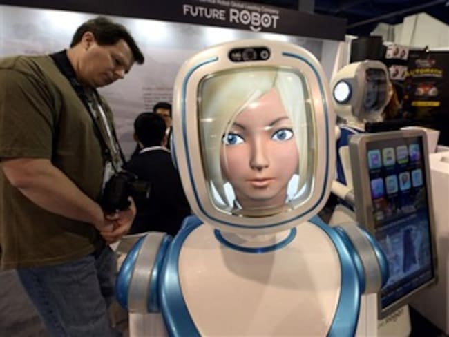 Un asistente observa un robot que ofrece un servicio inteligente las 24 horas en el CES. Foto: Efe.