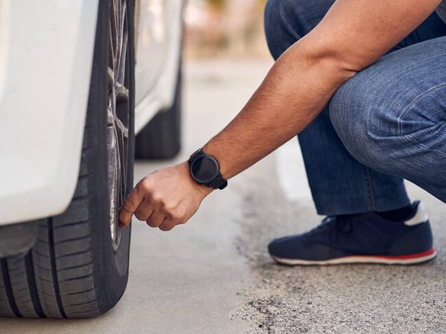 Close-up of unrecognizable man checking the status of his car&#039;s tires. Concept of driving and driving safety.