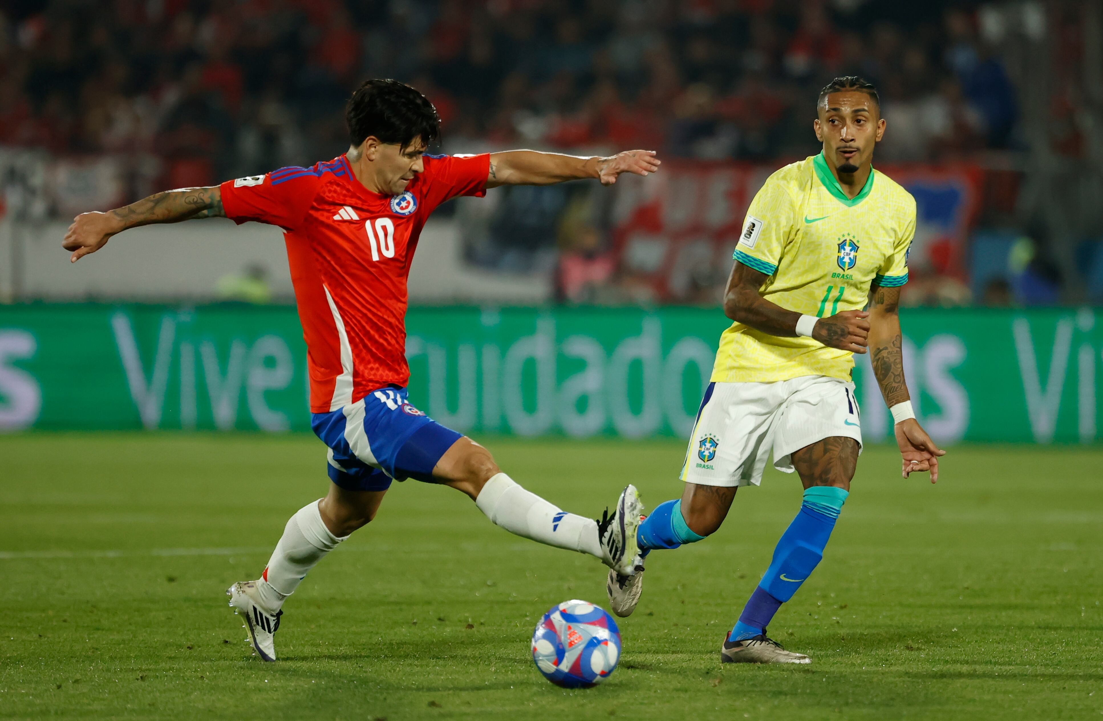 AMDEP8624. SANTIAGO (CHILE), 10/10/2024.- Víctor Dávila (i) de Chile disputa un balón con Raphinha de Brasil este jueves, en un partido de las eliminatorias sudamericanas para el Mundial de 2026 entre Chile y Brasil en el estadio Nacional Julio Martínez Prádanos en Santiago (Chile). EFE/ Elvis González