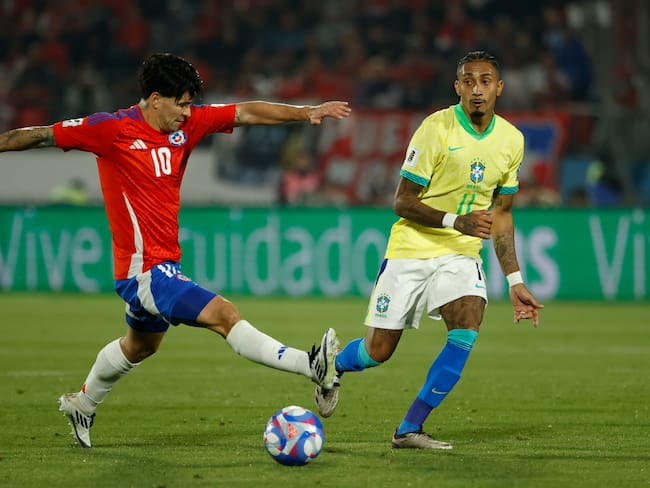AMDEP8624. SANTIAGO (CHILE), 10/10/2024.- Víctor Dávila (i) de Chile disputa un balón con Raphinha de Brasil este jueves, en un partido de las eliminatorias sudamericanas para el Mundial de 2026 entre Chile y Brasil en el estadio Nacional Julio Martínez Prádanos en Santiago (Chile). EFE/ Elvis González